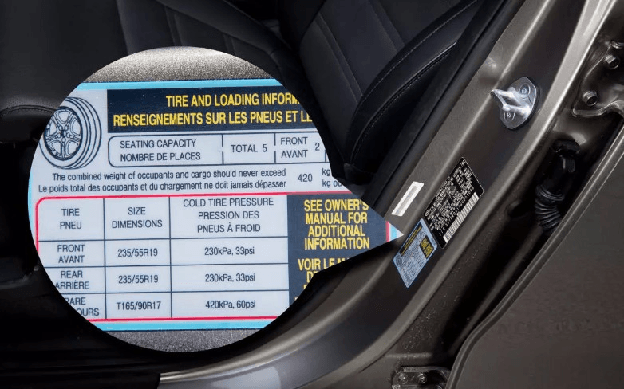 Tire pressure placard inside the driver's door showing the manufacturer's recommended psi