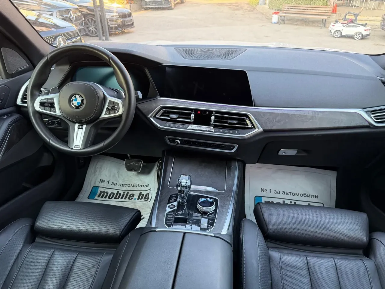 Изглед към таблото на BMW X5 G05 с iDrive 7 екран и черна кожа